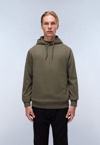 Sudadera color verde oliva con cordón, dobladillo y puños acanalados, y un pequeño emblema en el pecho. Tejido suave, corte relajado.