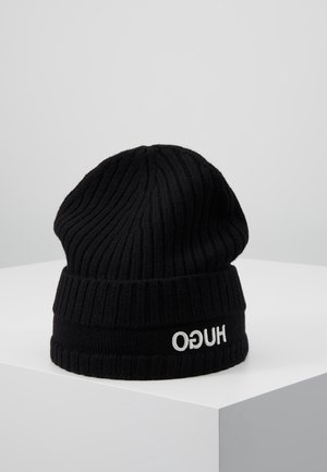 Gorro de punto acanalado negro con puño doblado que muestra el logo "HUGO" en blanco cosido al revés.