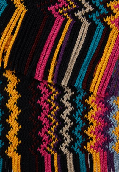 Meerkleurige geweven textiel met een zigzagpatroon in roze, geel, blauw en zwart, met franjes langs de randen.