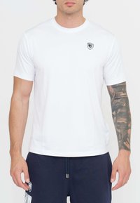 T-shirt bianca a maniche corte realizzata in un tessuto liscio, con un piccolo logo nero sul petto e un design classico con collo a giro.