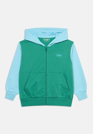 Green and light blue children's zip-up hoodie with front pockets and "TINY" logo on the chest and inside collar.