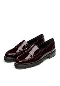 Burgunderfarbene Lackleder Slipper mit runder Zehenpartie, goldenen Nietenakzenten und einer robusten schwarzen Sohle für guten Halt. Glatte Textur und elegantes Design.