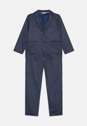 Ναυτικό μπλε κοστούμι με ραβδώσεις, που περιλαμβάνει ένα σακάκι με δύο μπροστινές τσέπες και κουμπί κλεισίματος, σε συνδυασμό με αντίστοιχες ίσιες παντελόνες.