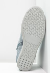 Light blue sneaker with a textured upper and a patterned rubber sole. Contains a smooth, flat area on the heel and is labeled size 37.