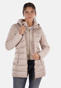 Giacca imbottita beige con cappuccio, presenta una zip frontale, tasche laterali e un design trapuntato. Realizzata con materiale liscio e leggero.