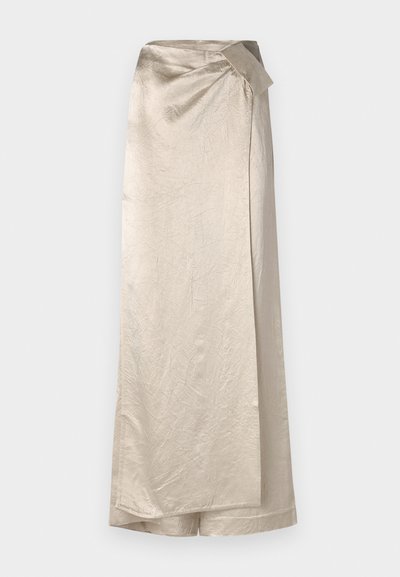 Long, beige skirt made from a shiny, textured fabric. Features a wrap design with a side bow accent and a clean hem.