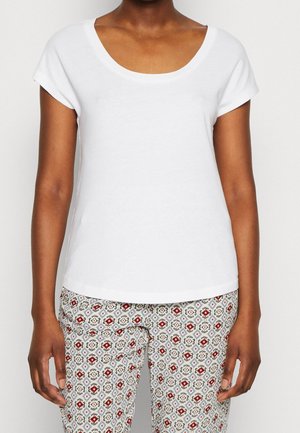 Witte kortemouwen T-shirt met een ronde halslijn, gemaakt van zachte stof. Gecombineerd met gestreepte broek met bloem- en geometrische ontwerpen.