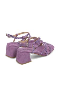 Sandali a blocco di pelle scamosciata viola con cinturini incrociati decorati con strass. Texture liscia con soletta imbottita.