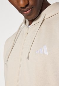 adidas Sportswear Bluză de molton cu fermoar - offwhite