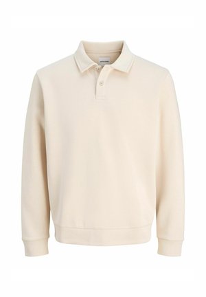 Polo beige à manches longues en tissu doux, avec un col classique, une patte de boutonnage à deux boutons et des poignets élastiques pour un ajustement confortable.