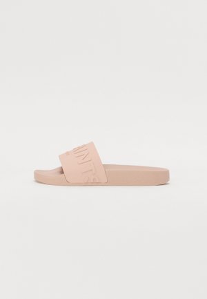 Lyserød gummisko med en bred rem med præget tekst. Sålen er flad og tekstureret for bedre greb. Enkel, minimalistisk design.