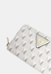 Portafoglio bianco con motivo a trapunta in tonalità di grigio. Presenta una placca con logo triangolare e una zip. Il materiale sembra sintetico.