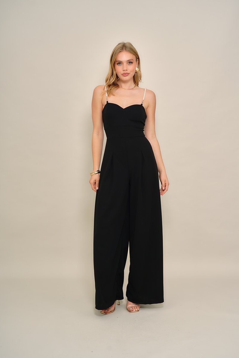 Fekete overall szív alakú nyakkivágással és bő szárú fazonnal. Gyöngyös pántokkal és finom redőkkel díszítve. Simogató, könnyű anyagból készült.