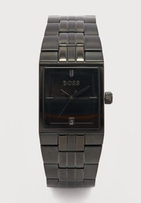Μαύρο ορθογώνιο ρολόι χειρός με μεταλλική στεφάνη με κρίκους, αναλογική οθόνη, λογότυπο BOSS και παράθυρο ημερομηνίας που δείχνει 23 στο καντράν.