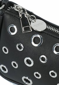 Borsa in pelle nera con accenti in occhiali argentati, chiusura con zip e un'etichetta metallica rotonda. Presenta una superficie testurizzata e distintivi disegni circolari.