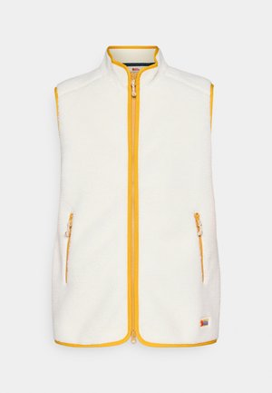 Villapusero vaaleassa kremissä, jossa on keltainen vetoketju ja reunat. Varustettu kahdella vetoketjullisella sivutaskulla ja pystykauluksella. Pehmeä pinta, rento muotoilu.