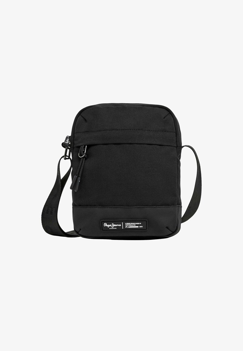 Bolso cruzado negro de forma rectangular, hecho de tela duradera. Cuenta con un bolsillo con cremallera en la parte frontal y una etiqueta de marca en la parte inferior.