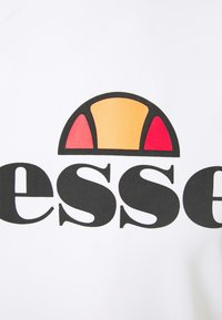 Bijela pamučna majica s okruglim logotipom u crvenoj, narančastoj i crnoj boji. Velikim crnim slovima ispod logotipa ispisano je "esse".