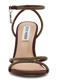 Sandalo con tacco alto in camoscio marrone, con due cinturini decorati con cristalli, cinturino alla caviglia con fibbia argentata e suola beige.