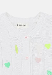 Λευκό πλεκτό ζακέτα με ανάγλυφη υφή, διακοσμημένη με εφαρμογές σε παστέλ αποχρώσεις σε σχέδια καρδιάς και σανίδας σέρφ, με κούμπωμα κουμπιών. Ορατή ετικέτα μάρκας.