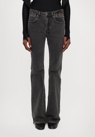 Jeans noirs évasés avec une finition décolorée, cinq poches et des accents en métal sur la taille. Fabriqués en denim avec une légère élasticité.