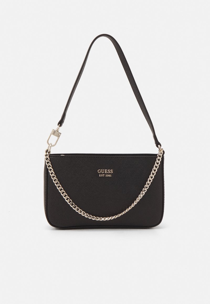 Sac à bandoulière noir Guess avec détail chaîne dorée et texte logo "GUESS EST 1981" sur le devant sur fond uni.