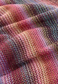 Multicolored woven fabric with a textured zigzag pattern, featuring shades of pink, purple, gold, blue, and green.