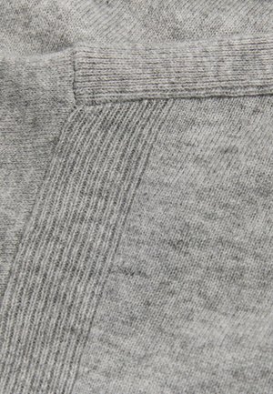 Tissu gris avec un motif de tricot texturé, présentant une section lisse et un bord côtelé, mettant en valeur un matériau textile doux et confortable.