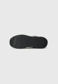 Semelle de sneaker en caoutchouc noir avec un grip texturé et un motif de lettres en relief. Présente un design résistant à l'usure adapté à diverses surfaces.
