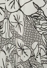 Diseño floral y geométrico en negro sobre tela blanca, que presenta grandes hojas y pequeñas flores con detalles en líneas y textura.