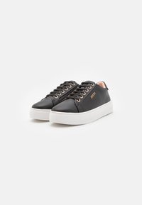 Sneakers in pelle nera con occhielli dorati, suola piatta bianca e branding discreto. Punta conica e design con lacci, con un interno in accentuato rosa.