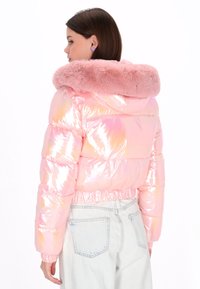 Kurtka puchowa w mieniącym się różowym materiale, z kapturem obszytym sztucznym futrem, elastycznymi mankietami oraz dopasowanym, krótkim krojem.