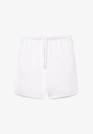 Shorts à taille élastique blanche avec cordon de serrage et poches latérales, en tissu doux, présentés sur un fond uni.