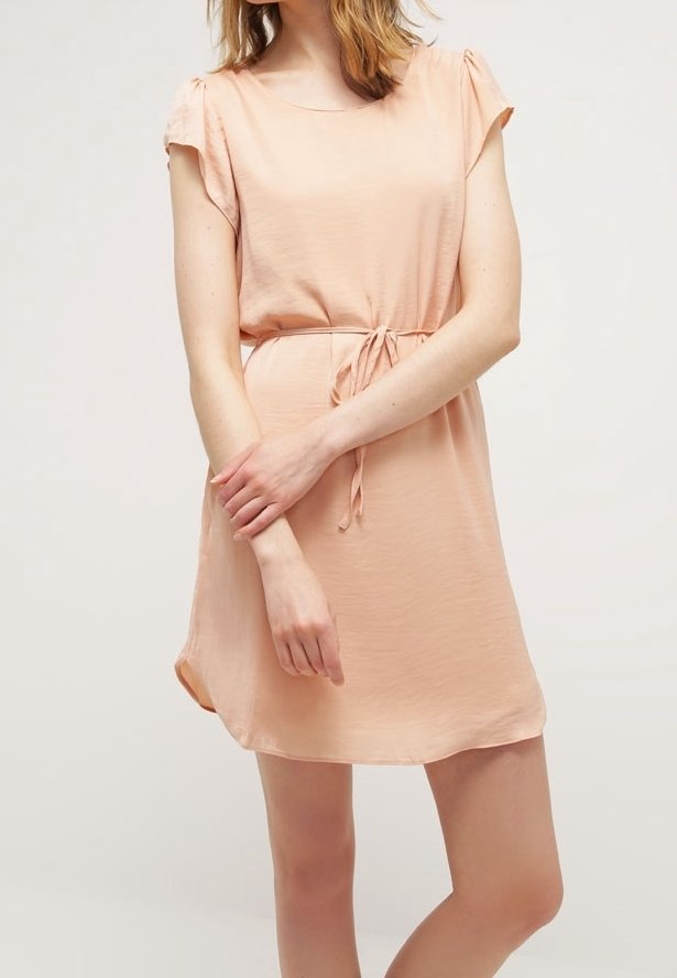 Vestido de color durazno hecho de tela ligera, con mangas cortas, escote redondo y detalle de lazo en la cintura. Textura suave, ajuste relajado.