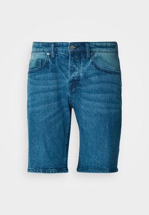 Shorts de mezclilla en un lavado azul medio. Cuenta con un cierre de botón, cinco bolsillos y un ligero desgastado con un corte recto.