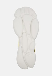 White rubber sole of footwear featuring a textured surface, rounded and elongated shapes, and a stamped size "42."