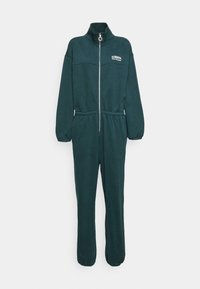 Dunkelgrüner Jumpsuit aus weichem Stoff, mit hohem Kragen, Frontreißverschluss, elastischem Bund und elastischen Bündchen an den Knöcheln.