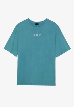 Teal cotton t-shirt, short sleeves, crew neck, featuring a central graphic of a star and crescent moons in white. Soft, casual design.