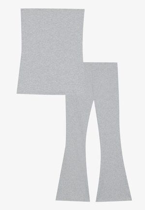 Grijze katoenen top en set met uitlopende leggings. De top is rechthoekig; de leggings zijn aansluitend met een flared onderkant. Zachte, gladde textuur, zonder patronen.