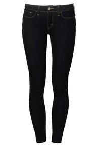 Jeans skinny de mezclilla negra con cinco bolsillos, cierre frontal de botón y cremallera, costuras naranjas en contraste y un diseño ajustado.