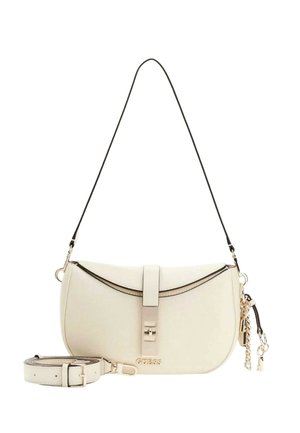 Sac bandoulière Guess couleur crème avec fermeture à l'avant, rabat bordé de noir, bandoulière amovible, et accessoire porte-clés doré sur fond blanc.