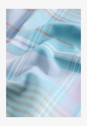 Šviesiai mėlyna langeliais audinys su minkšta tekstūra. Jame yra plonos juostos pastelinių spalvų ir subtilūs audimo akcentai, kurie kuria sluoksniuotą išvaizdą.