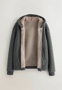 Felpa grigia con zip, foderata in morbida sherpa beige, dotata di cappuccio, due tasche frontali e polsini e orlo a coste.