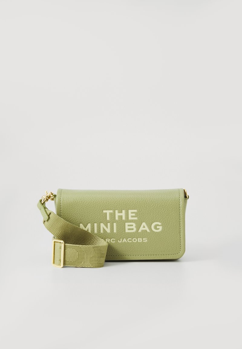 Green textured leather mini crossbody bag with adjustable strap and gold hardware, front text reads "THE MINI BAG MARC JACOBS."