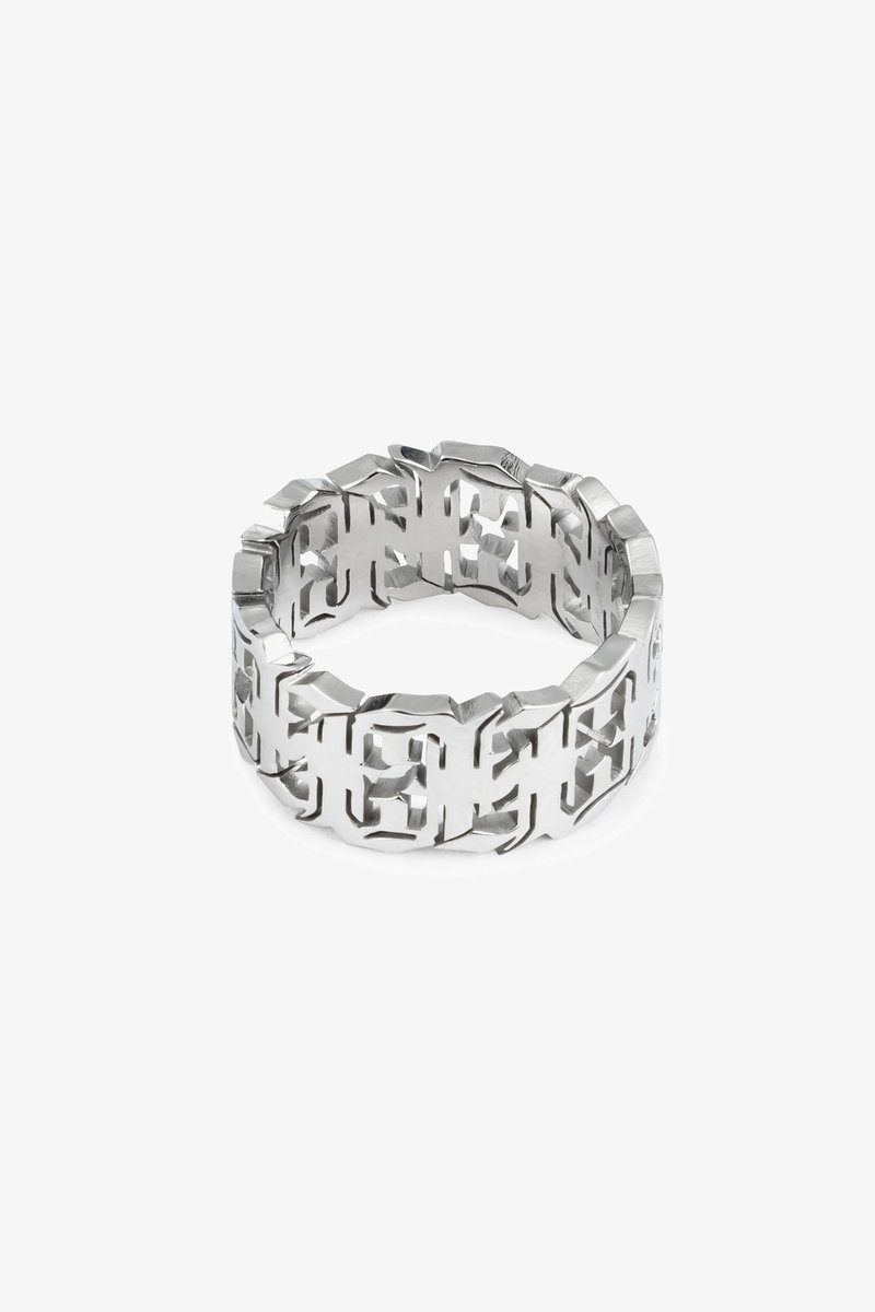 Silver metal ring with an intricate cutout design. Features smooth edges and a geometric pattern throughout its surface.