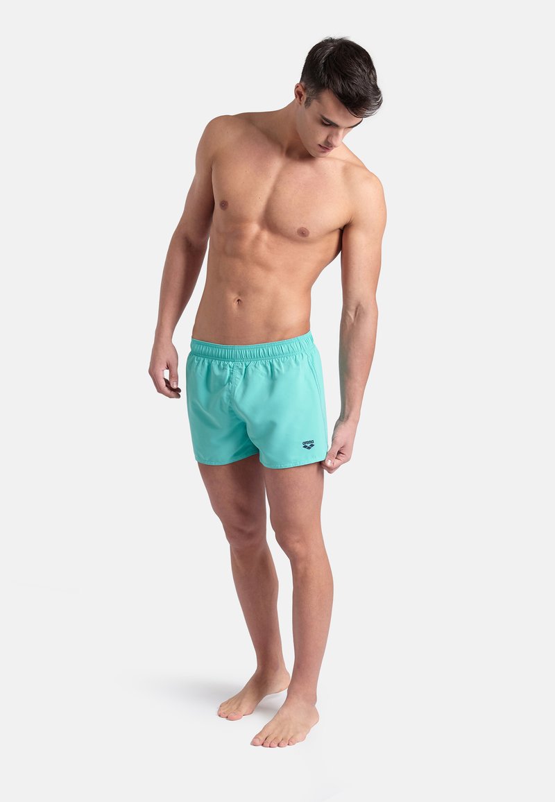 Jasnoniebieskie szorty kąpielowe z elastycznym paskiem w talii, z logo po lewej stronie. Gładka faktura i krój powyżej kolan.