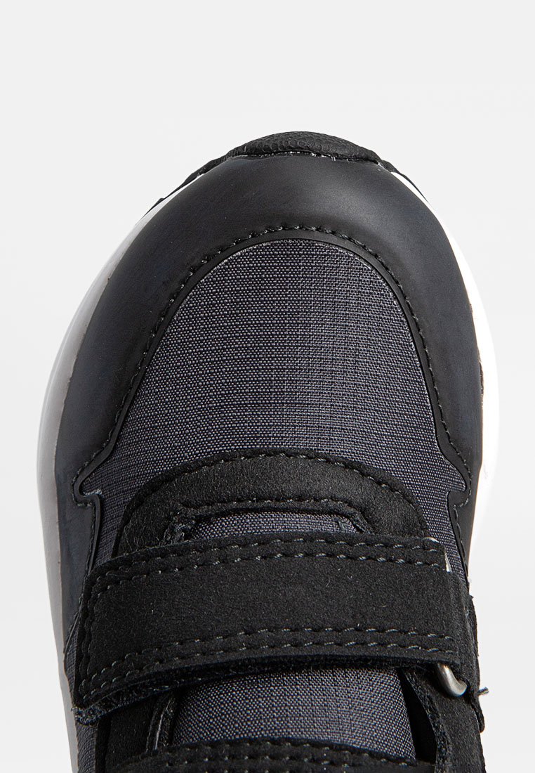 Schwarze Sneaker mit einem Obermaterial aus Textil und einer glatten synthetischen Zehenkappe. Klettverschlüsse am Obermaterial verbessern den Halt und die Passform. Weiße Sohle.