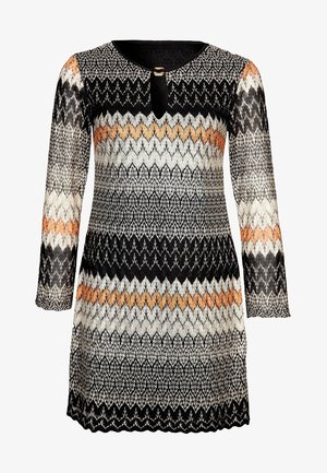 Pitkähihainen neulemekko, jossa on chevron- ja siksak-kuviot mustana, valkoisena, harmaana ja oranssina, pyöreällä pääntiellä, jossa etuosassa avaus ja solki.