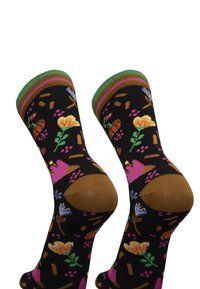 Schwarze Socken mit einem floralen Muster in Pink, Gelb und Grün, mit braunem Zeh und Ferse. Detail mit grünem und lila gestreiftem Bündchen.