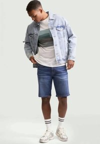 Light blue denim jacket, white t-shirt with horizontal stripes, blue denim shorts, and silver sneakers with white and black striped socks.